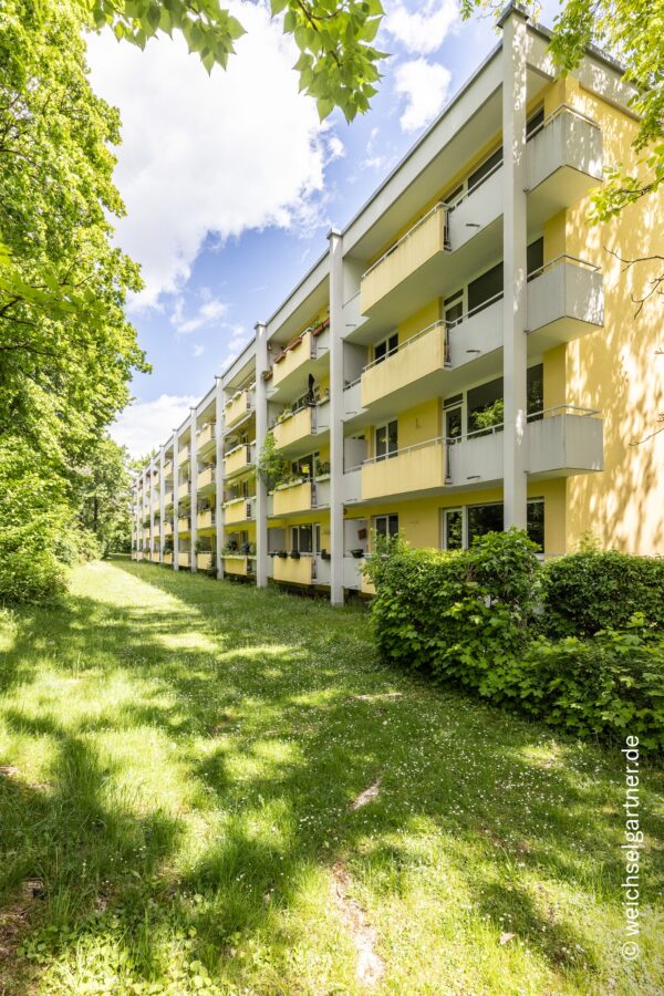 Direkt am Park: Charmante, bezugsfreie Eigentumswohnung mit Westbalkon und Blick ins Grüne - Westliche Hausansicht