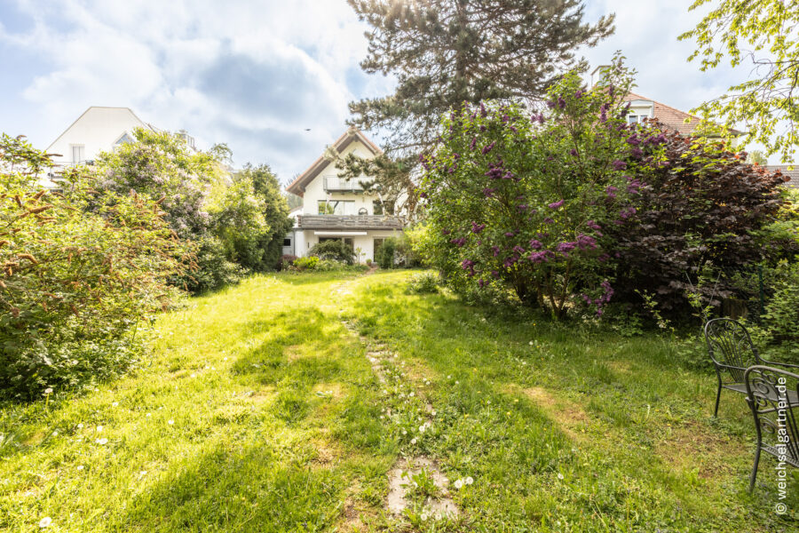 Eigentumswohnung mit herrlichem West-Garten, extra Hobbykeller und zwei Garagen - Blick vom Garten auf das Haus