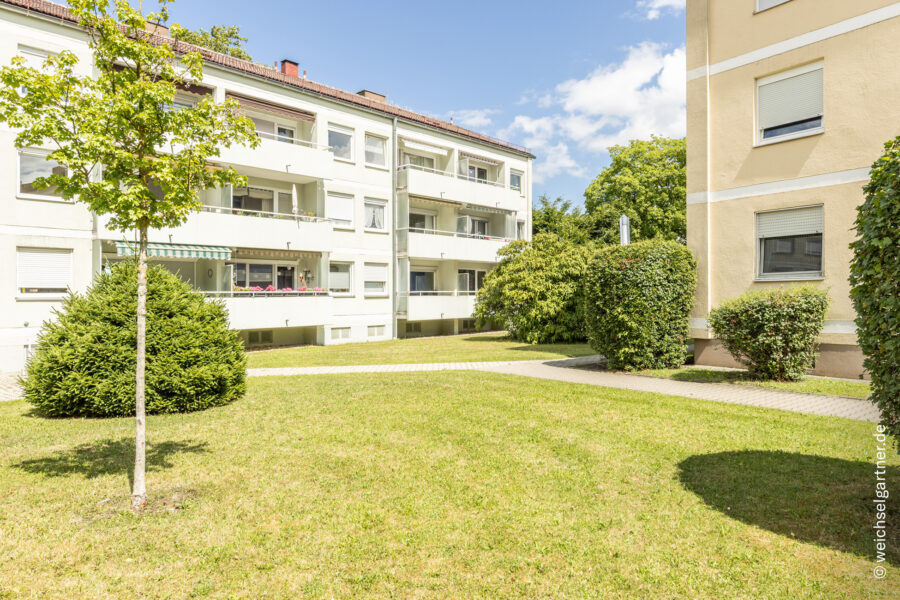Renovierungsbedürftige Wohnung mit Süd-Loggia und Einzelgarage - Rückansicht des Gebäudes